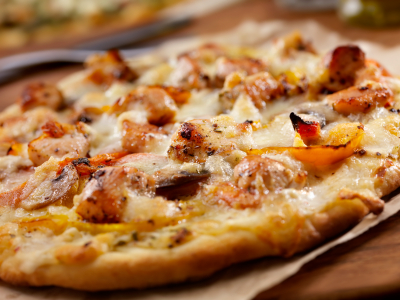 A pollo pizza with roasted yellow peppers.