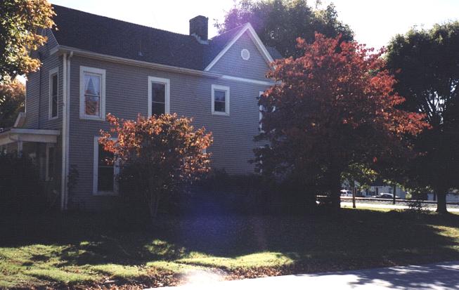 Just around the corner is a slate blue home surrounded by russet-colored foliage.