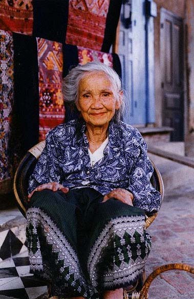 Op de achtergrond traditionele gewaden uit Laos.