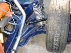 Back of passenger's side front suspension with chrome radiator hose to the rear