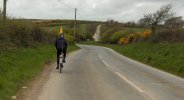 [ Roberto cycling down a picturesque country road ]