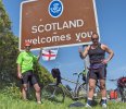 [ Gary and Roberto by a road sign at the Scottish border ]