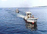 Tugboats towing what appears to be a boom