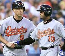 Tony Batista gets congratulated by Cal Ripken Jr after hitting his first homer as an Oriole
