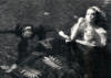 Man in water face down. Woman in dress in the pool blowing bubbles.