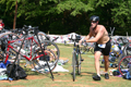 Man rolling bicycle out of area where all the bikes are parked.