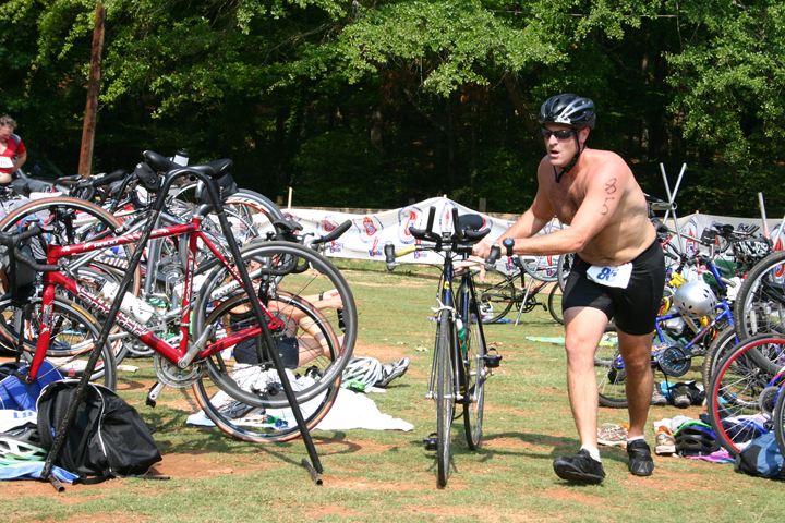 Man Rolling bike out of place where bikes are parked.