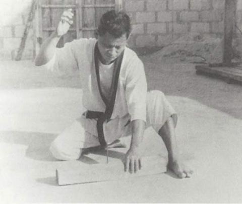 Tatsuo Shimabuku driving a nail with his hand