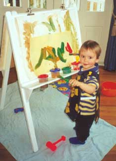 A young artist does his stuff with finger paints.
Be sure to put a cover on the floor to catch the drips!