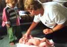 Plunket Nurse Marilyn Hemming weighs Peter, while brother William watches at left.