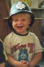 Laughing policeboy Matthew, aged 2, patrols his beat.