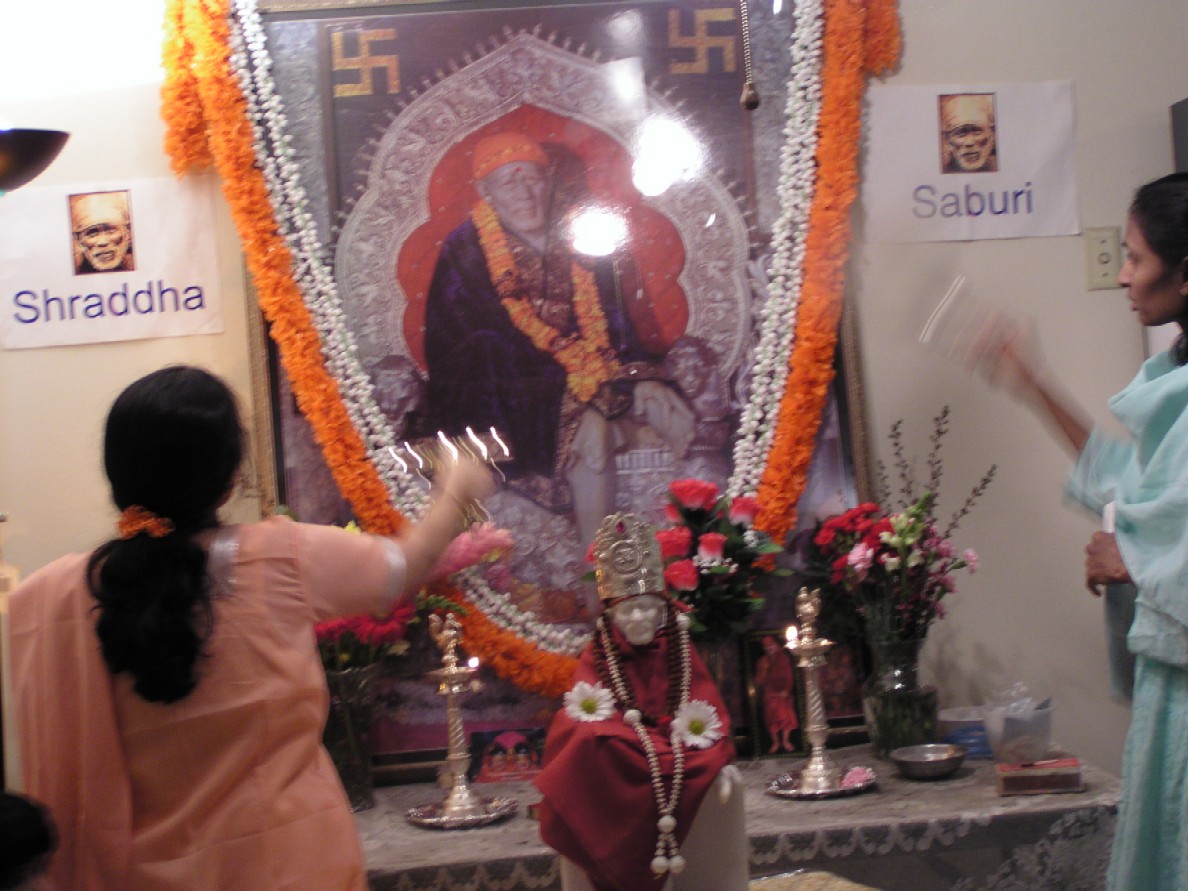 Devotees offering arti to Baba