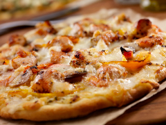 A pollo pizza with roasted yellow peppers.