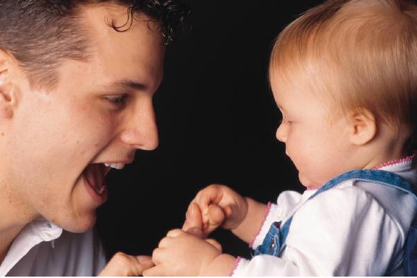 Dad smiling at baby daughter