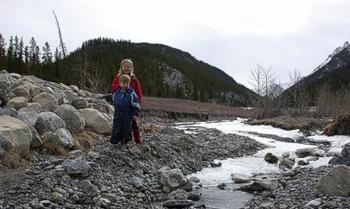 Hilla ja Eelis kaivelemassa puronvartta ja rakentamassa kivitonttuja; Kananaskis, Alberta 31.3.2006