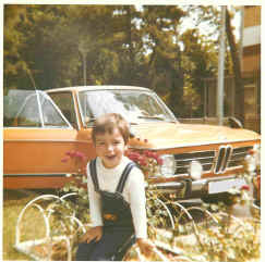 Alex als Kind vor dem Auto