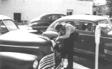 Raymond Anderson, policeman giving a parking ticket on Palo Pinto St. 1947
