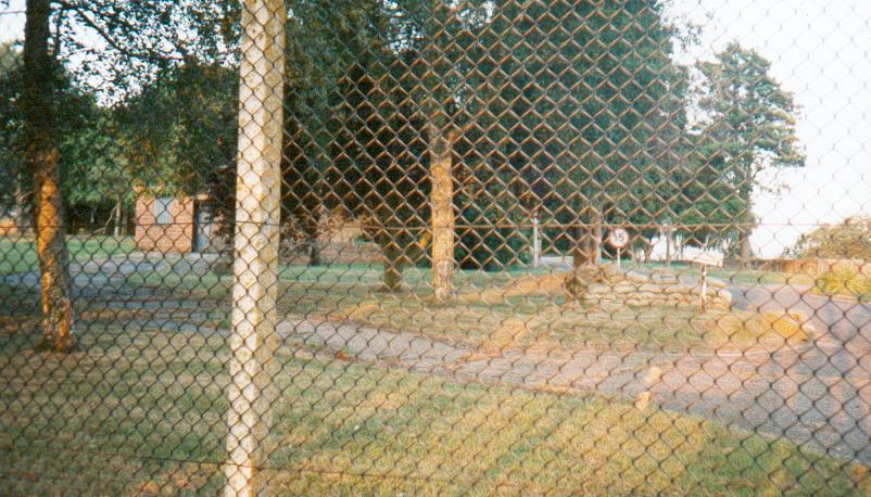 (c.1996) the machine gun nest, constructed of sand bags, steps from the main gate, with the strong house in the rear