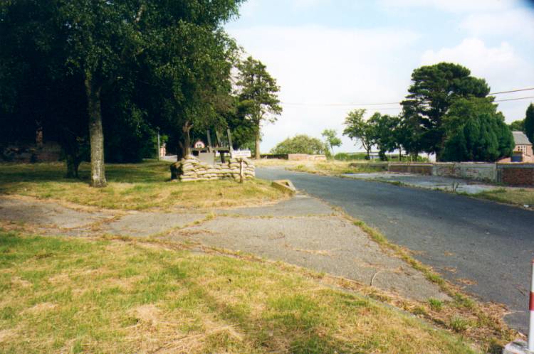 showing clear the machine nest, and further up the road, with another builidings brick base and the Estates office building just visible between trees to the right (picture by Brian Kitching)