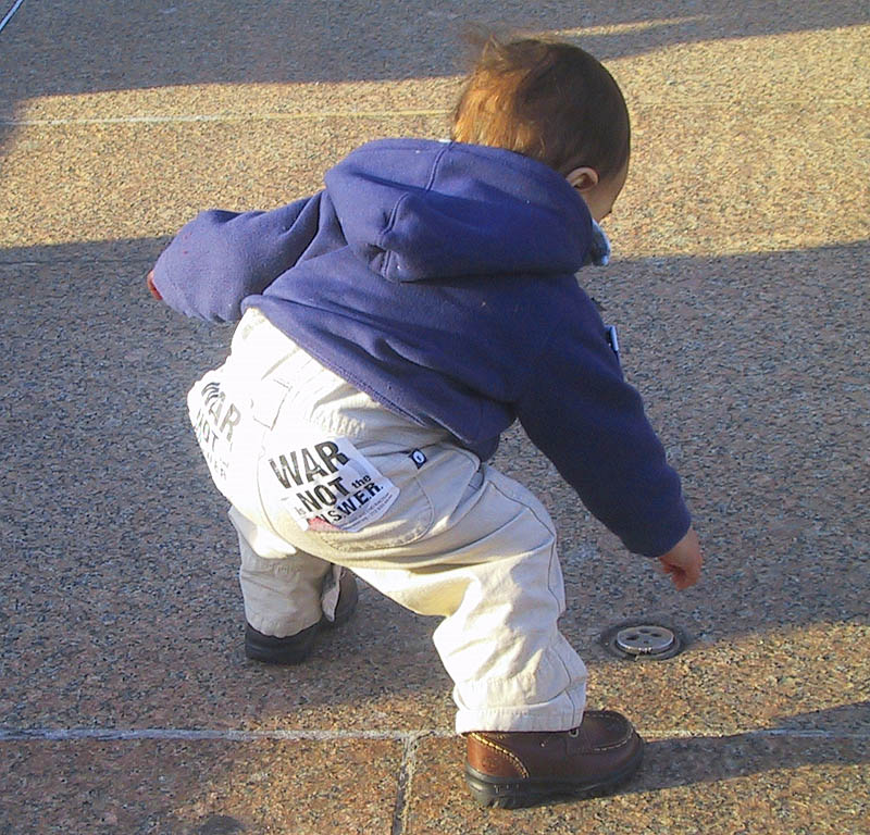 A young participant in the March 18th 2003 DC rally proudly shows his signs for A.N.S.W.E.R. (Act Now to Stop War and End Racism)