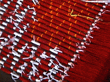 blocks of red silk thread wrapped in white cellophane before dyeing