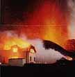 House burning on Heimaey Island after volcanic eruption.
