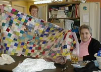Two IDEAs members with a  patchwork quilt.