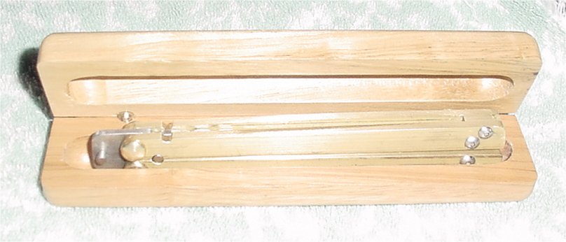 Shows Balisong in an wooden hinged ink pen box