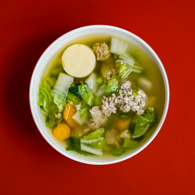 asian soup dish in a white bowl on a red bakcground