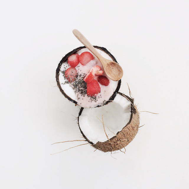 coconut split in half with berries and chia seeds in one half