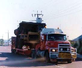 Iron Ore Truck being carted by semi trailer down the main street