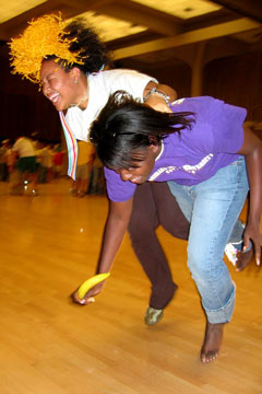 LSU Ambassadors Angel Cutno and Danelle Walker compete in the �Tandem Banana Ping-pong Hockey.� In this competition, participants are joined together at the ankle and must push a ping-pong ball the length of the course using only a banana.
