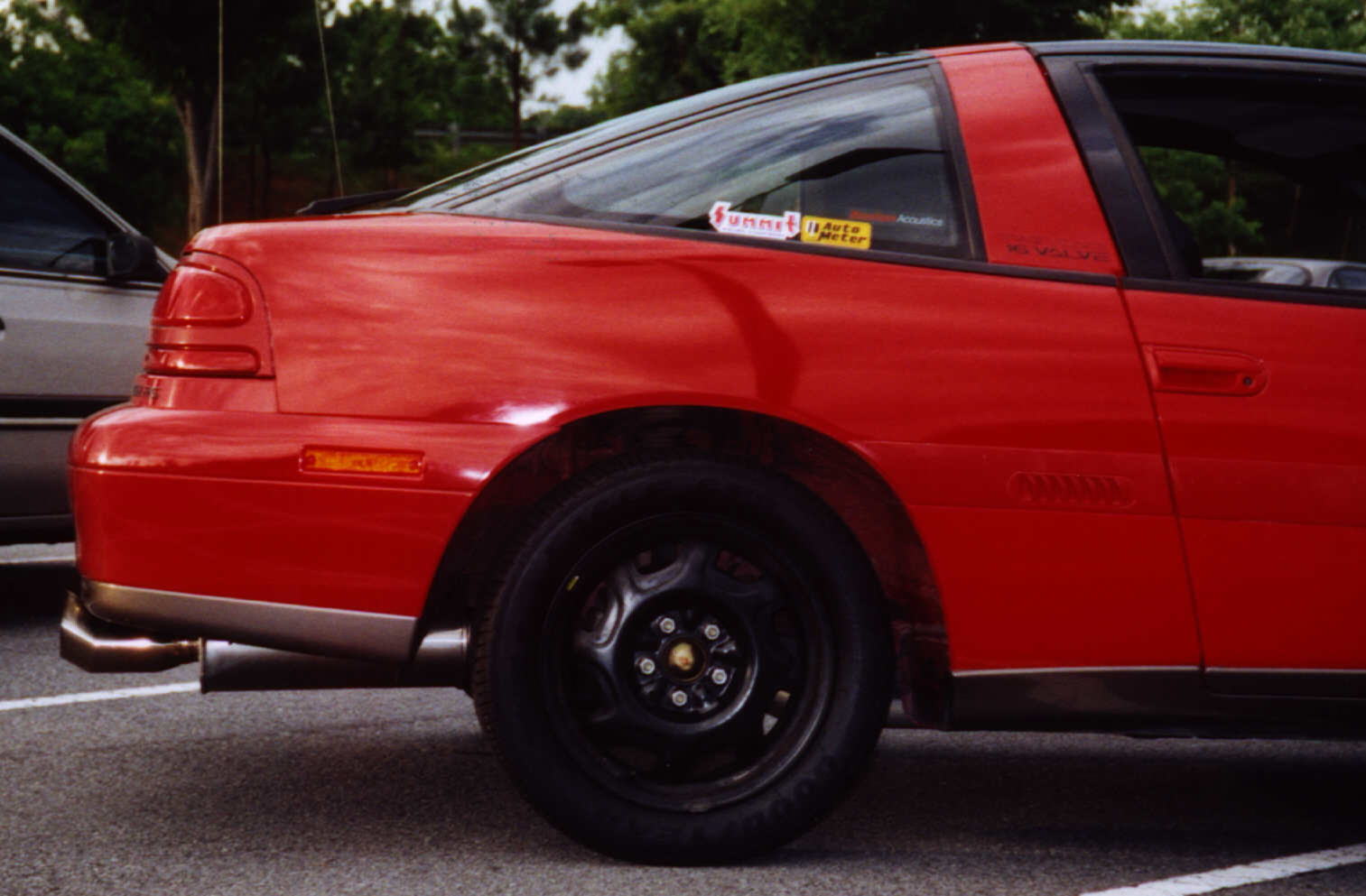 Custom exhaust...maxspeed muffler...attached to 3" turbo-back piping. (don't ya just love those stock wheels/minus wheel covers!).. HAHA