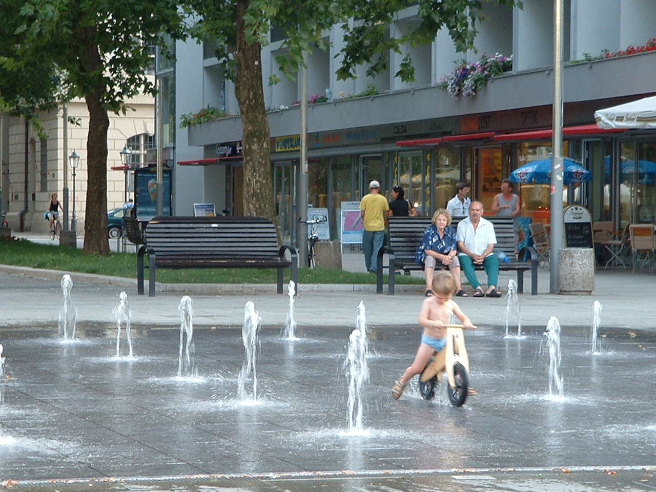 this kid LOVED riding his bike in the fountain!...