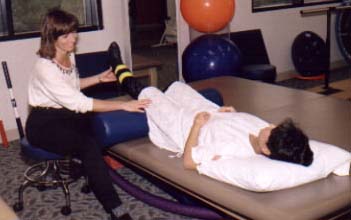 Physical therapist working patients leg