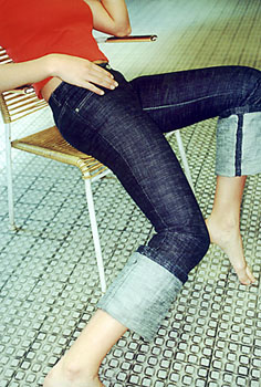 Jeansgirl in zu engen Jeans auf Stuhl im Cafe