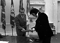 Elvis - "Dickie, look at this dandelion photo. We gotta watch this JAF. He could be a real hippie hound dog later on..."  Nixon - "Sock it to me, Mr. Presley. I'll put Mr. Figure on my list, and thanks for the pistol."