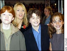 O trio de protagonistas, com Rowling ao fundo: da esquerda para a direita, Rupert Grint (Ron ), Daniel Radcliffe (Harry) e  Emma Watson (Hermione) 