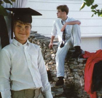 Dave tries on Dan's mortarboard while Dan tries to come up with a way out of sitting through graduation.  (Summer 1997)
