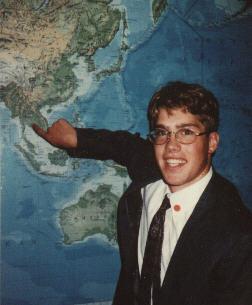 Sam at the MTC map, pointing to Thailand.