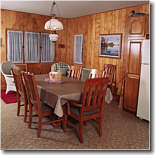 Large kitchen that includes microwave, stove, tressl table, dishes, and other accessories