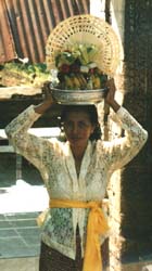 Een Balinese vrouw brengt offergaven naar de tempel.