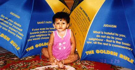 Devishi Prabha Sankari poses with umbrellas bearing The Golden Rule