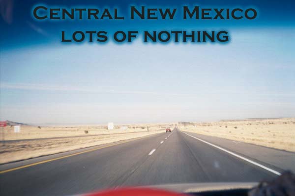 photo of central new mexico, road stretching straight away to horizon with bright yellow nothingness on either side.  Only one vehicle in view, deep blue sky above.  Titled, central new mexico, lots of nothing.