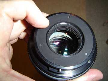pressing the rear pin in opens the aperture iris