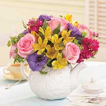 assorted flowers and pink roses in white ceramic teapot