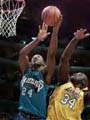 [Shaquille O'Neal trying to block a shot from an opponent]