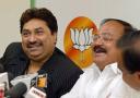 Bharatiya Janata Party (BJP) President N. Venkaiah Naidu, second right, laughs as Bollywood singer Kumar Sanu , left, sings a song in praise of Prime Minister Atal Bihari Vajpayee at a press briefing in New Delhi, India, Tuesday, March 16, 2004. Sanu formally joined the BJP Tuesday. In the background is the lotus symbol of the party.