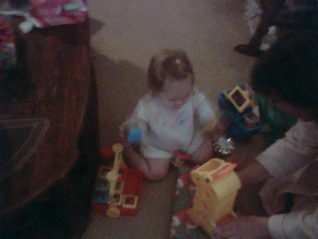 Kylie trying to figure out her toys.