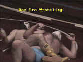 Powerhouse returns the favor with bodyscissors on Barefoot boy.
